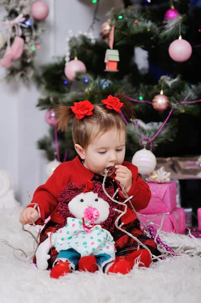 Niña en un vestido rojo en el fondo del árbol de Navidad —  Fotos de Stock