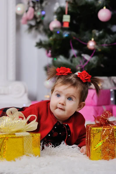 Niña en un vestido rojo en el fondo del árbol de Navidad —  Fotos de Stock