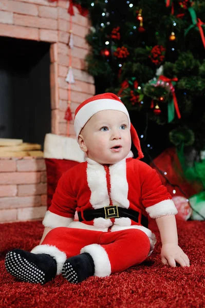 Baby boy dressed as Santa Claus.  in a  suit on the back — Stock Photo, Image