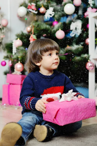 Niño con regalo en el fondo del árbol de Navidad — Foto de Stock
