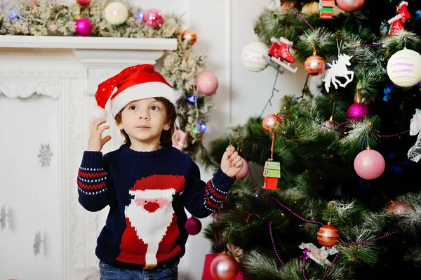 Niño en un sombrero de Navidad en el fondo de la Navidad — Foto de Stock