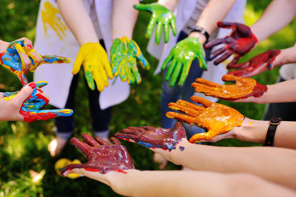 много рук в краске по кругу
