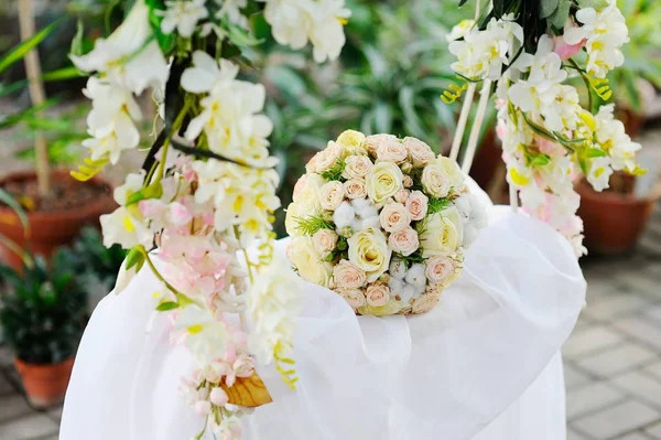 Ein Brautstrauß aus Blumen auf einer Schaukel — Stockfoto