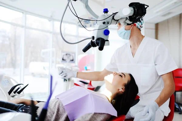 Tandarts onderzoekt patiënten tanden door middel van tandheelkundige microscoop — Stockfoto