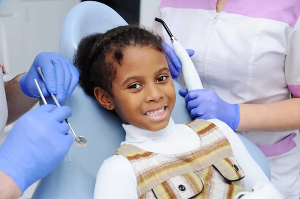 Chica con un niño de piel oscura en recepción en el dentista — Foto de Stock