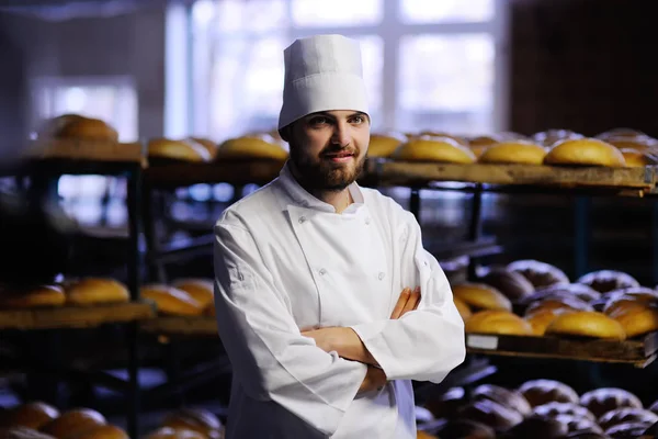 Пекарня в білій формі на фоні пекарні — стокове фото