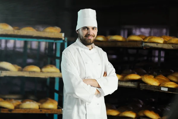 Пекарня в білій формі на фоні пекарні — стокове фото
