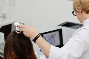 Doctor examines the hairy part of the patients head clipart