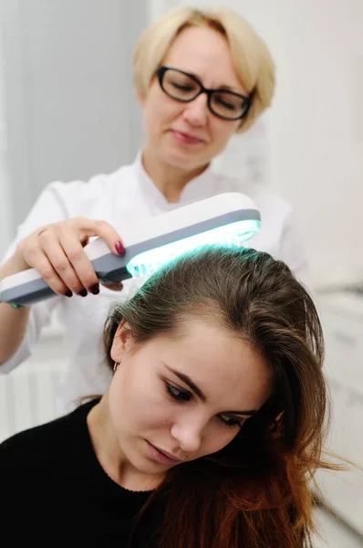 Dokter onderzoekt een speciale inrichting hoofdhuid met een UV-lamp — Stockfoto