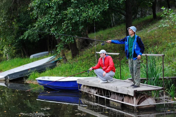 Zwei Fischer fangen Fische, die auf der Brücke stehen — Stockfoto