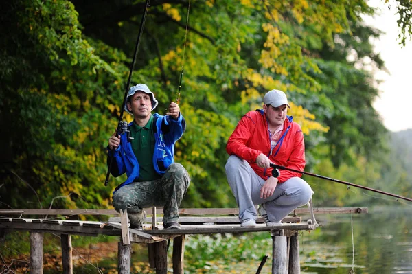 Zwei Fischer fangen Fische, die auf der Brücke stehen — Stockfoto