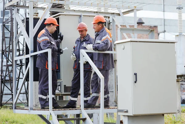 Operai che riparano un trasformatore nella centrale elettrica . — Foto Stock