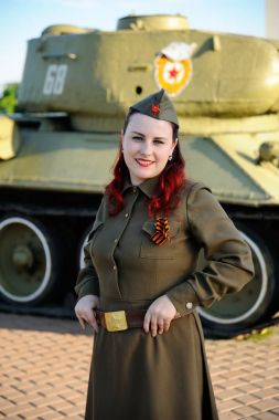 Tank arka plan üzerinde askeri üniformalı kız