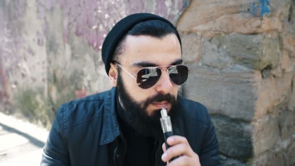 Bărbatul cu barbă fumează țigară electronică — Videoclip de stoc