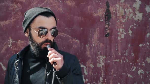 Бородатий чоловік курить електронну сигарету — стокове відео