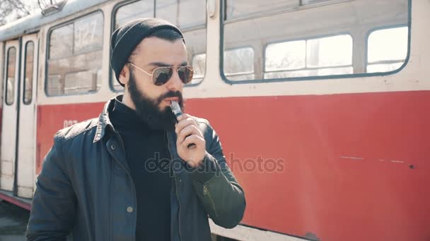 Бородатий чоловік курить електронну сигарету — стокове відео
