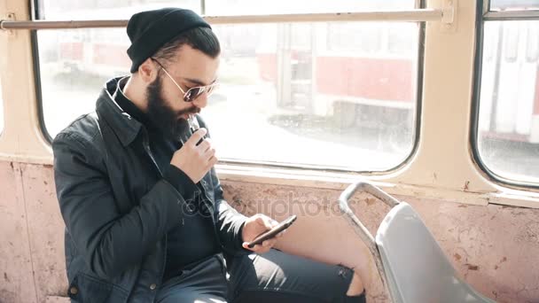 Mann raucht elektronische Zigarette in Straßenbahn — Stockvideo