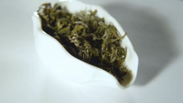 Rotation of green leaf tea in a white bowl — Stock Video