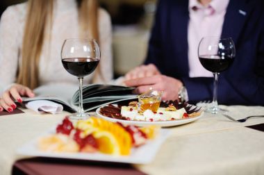 adam bir restoranda bir kızla menüden yemekler seçin