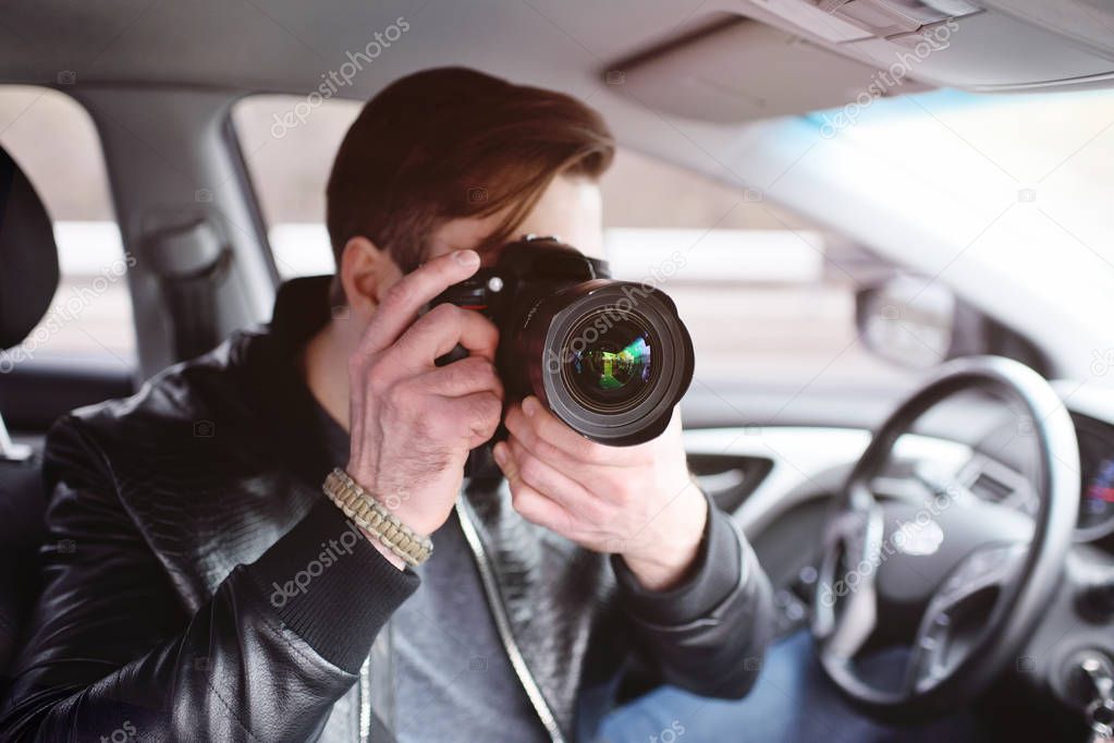 Young man with a camera in the car