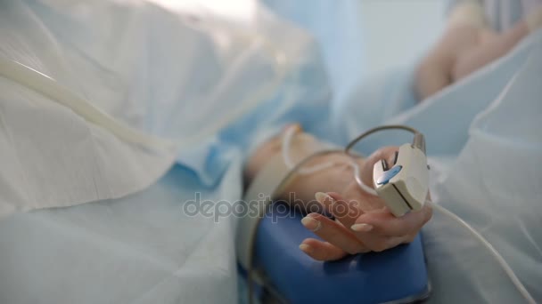 Pulse oximeter op de vinger van een patiënt closeup — Stockvideo