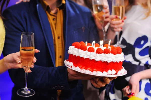 Födelsedagstårta med ljus och ett glas champagne närbild. — Stockfoto