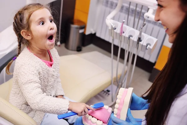 O dentista fala para a criança sobre higiene bucal — Fotografia de Stock