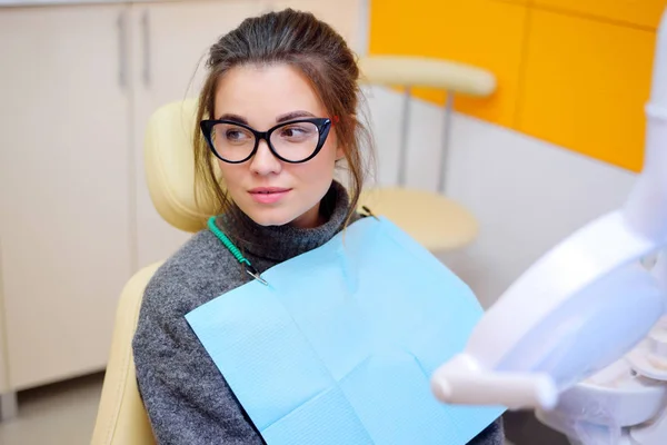 Fiatal nő, szemüveg, a fogászati szék — Stock Fotó