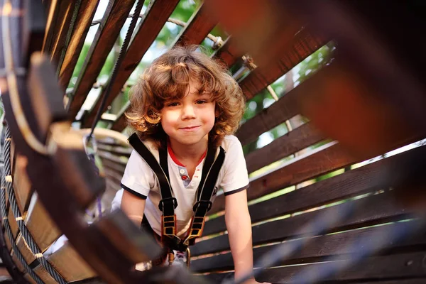 Lindo niño rizado en un parque de cuerdas — Foto de Stock