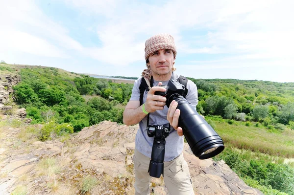 Um fotógrafo de vida selvagem tira fotos de uma paisagem — Fotografia de Stock