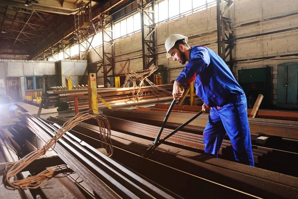 Il lavoratore in un casco bianco morde il filo d'acciaio con tronchesi — Foto Stock