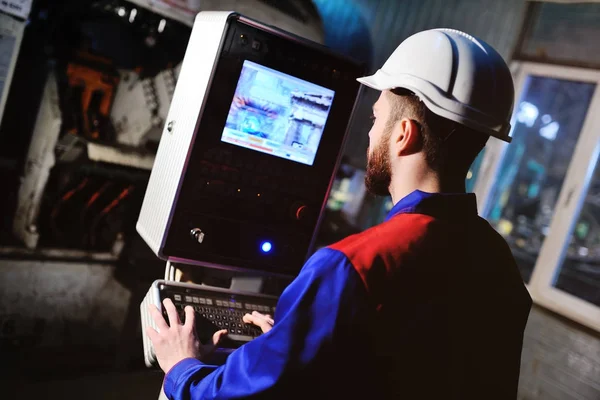 Mann arbeitet hinter der Schalttafel im Cockpit der Anlage — Stockfoto