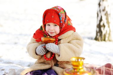 küçük kız bir kürk manto ve kırmızı eşarp Rus içme çay