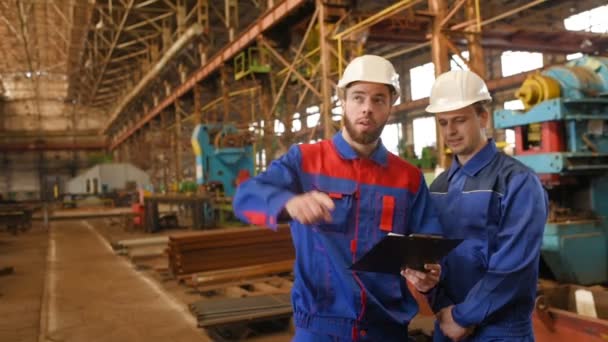 Dos trabajadores discuten un proyecto de construcción — Vídeo de stock