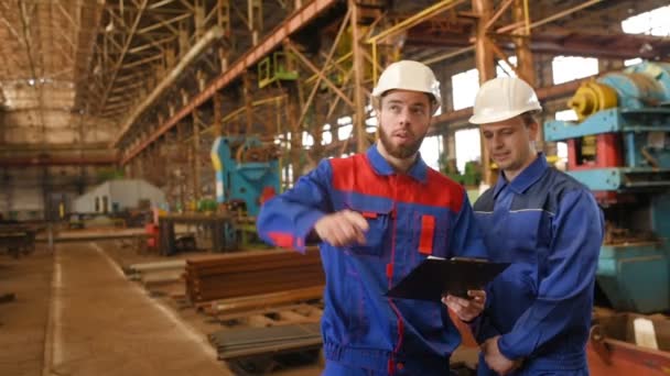 Dos trabajadores discuten un proyecto de construcción — Vídeos de Stock