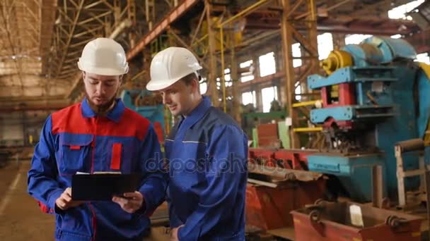 Dos trabajadores discuten un proyecto de construcción — Vídeos de Stock