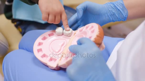 Un niño pequeño juega con un dentista en un dentista herramientas de juguete . — Vídeos de Stock