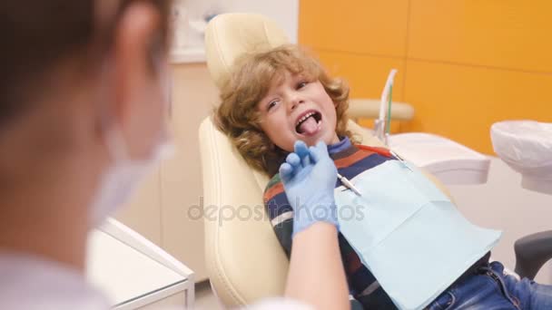 Χαριτωμένο μωρό σε ένα ριγέ πουλόβερ για υποδοχή στον οδοντίατρο — Αρχείο Βίντεο