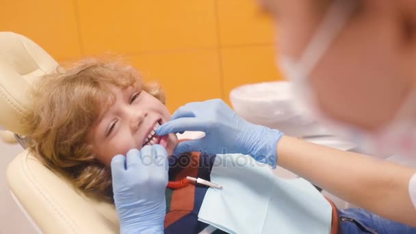 Diş hekimi resepsiyonda üzerinde çizgili kazaklı şirin bebek — Stok video
