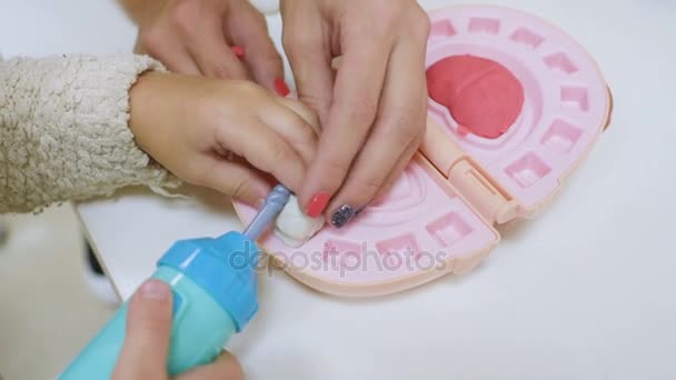 一个小孩子和牙医一起玩牙医玩具工具. — 图库视频影像
