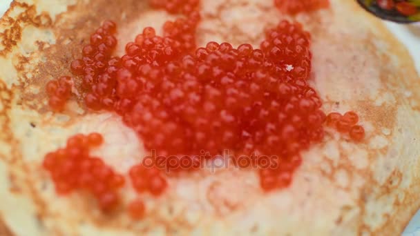 在节日餐桌的背景上, 有红鱼子酱的薄饼。庆祝狂欢节在俄国 — 图库视频影像