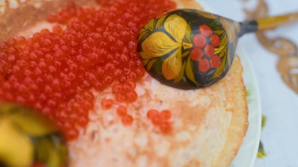 Pfannkuchen mit rotem Kaviar in Großaufnahme auf dem Hintergrund der festlichen Tafel. Karneval in Russland — Stockvideo