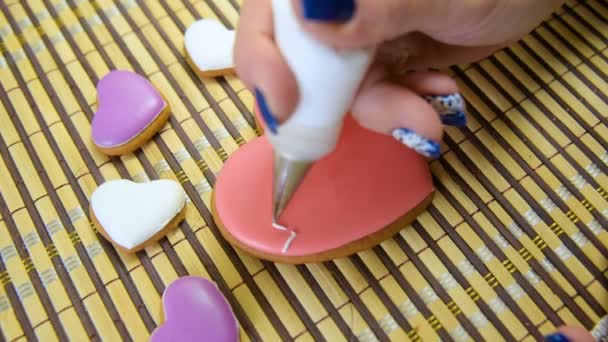 一只雌性糕点用心脏的形式在姜饼上用心电图做釉. — 图库视频影像