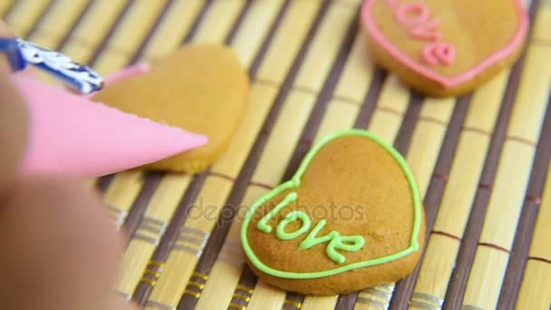 Žena zdobí cukrář a zdobí kroket s glazurou na Valentines Day. — Stock video