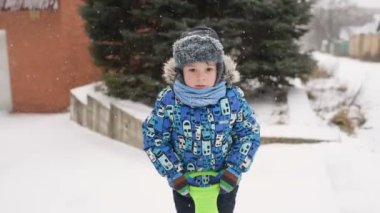 Çocuk kar kış arka plan üzerinde kameraya atar.