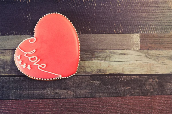 Pan de jengibre en forma de corazón decorado con esmalte rojo con el amor inscripción  . — Foto de Stock