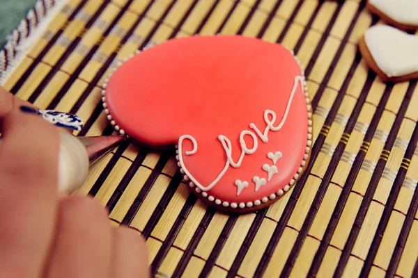 Pan de jengibre en forma de corazón decorado con esmalte rojo con la inscripción "amor ". — Foto de Stock