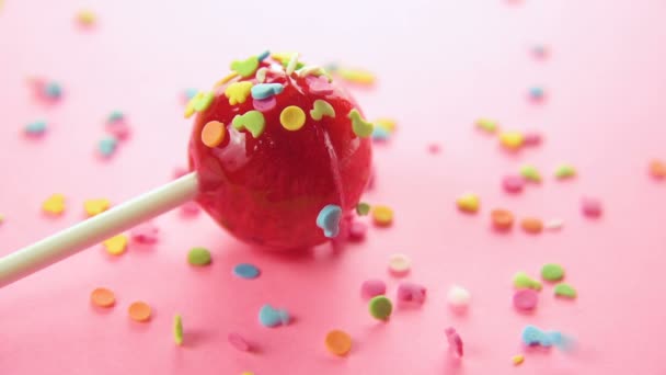 Pink round lollipop close-up on pink background. — Stock Video