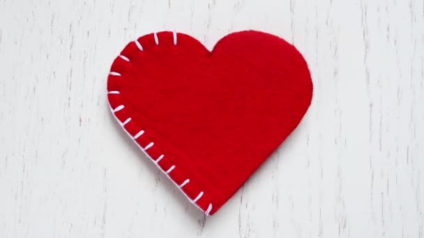 Červené srdce z plsti je lemována bílými vlákny — Stock video