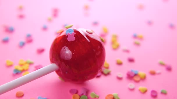 Pink round lollipop close-up on pink background. — Stock Video
